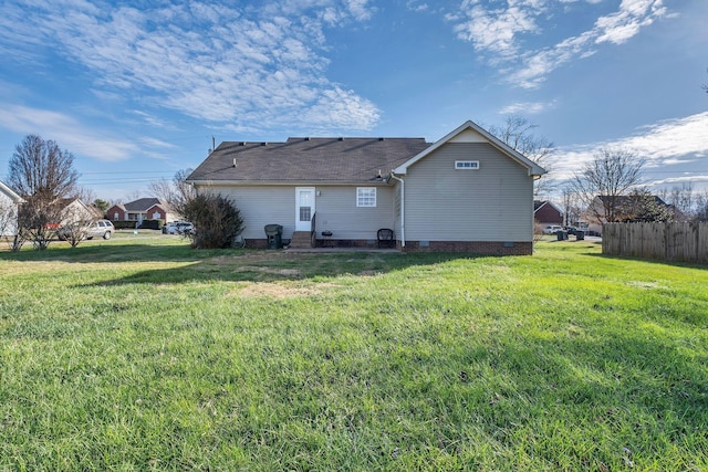 rear view of house featuring a lawn