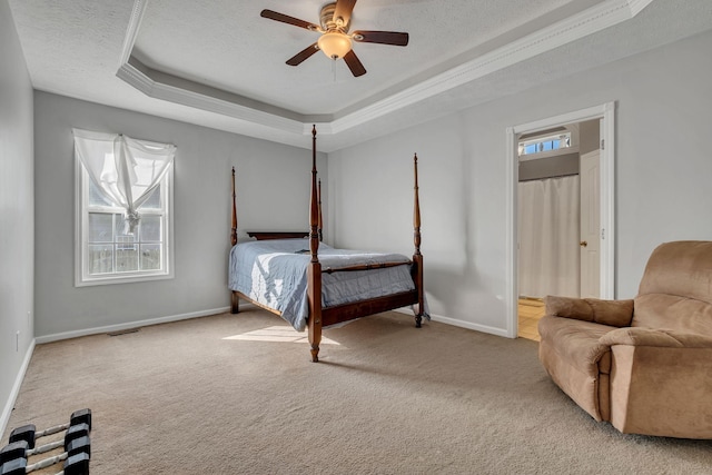 bedroom with a raised ceiling, ceiling fan, light colored carpet, and a textured ceiling