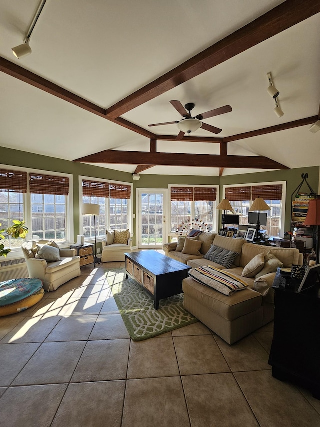 tiled living room featuring ceiling fan, plenty of natural light, lofted ceiling with beams, and track lighting