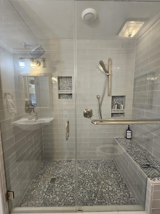 bathroom with ornamental molding and walk in shower