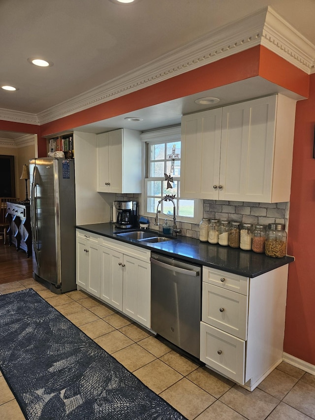 kitchen with decorative backsplash, stainless steel appliances, sink, light tile patterned floors, and white cabinets