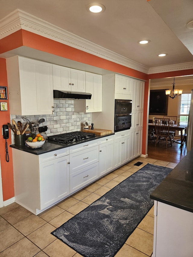 kitchen featuring gas cooktop, black oven, light tile patterned floors, and white cabinetry