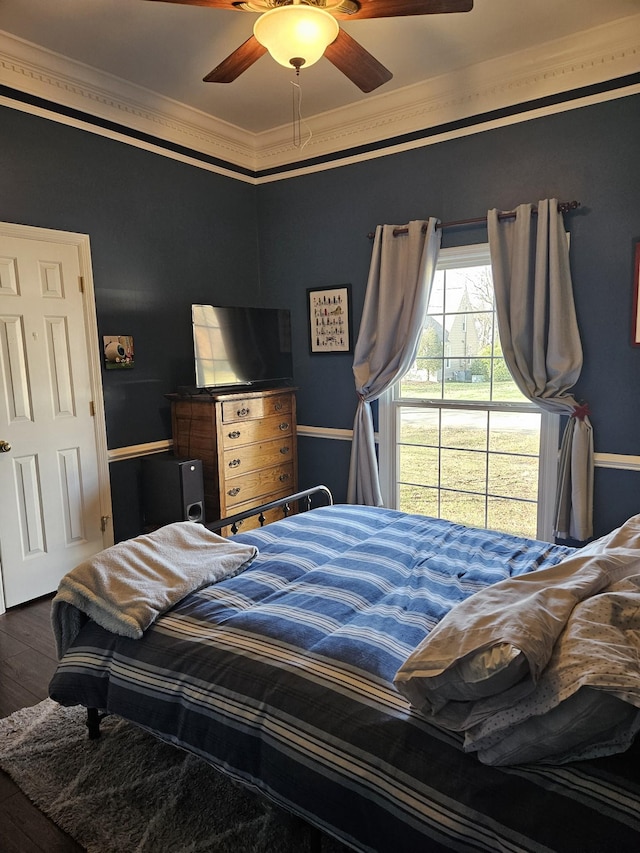 bedroom featuring dark wood-type flooring, ceiling fan, and ornamental molding