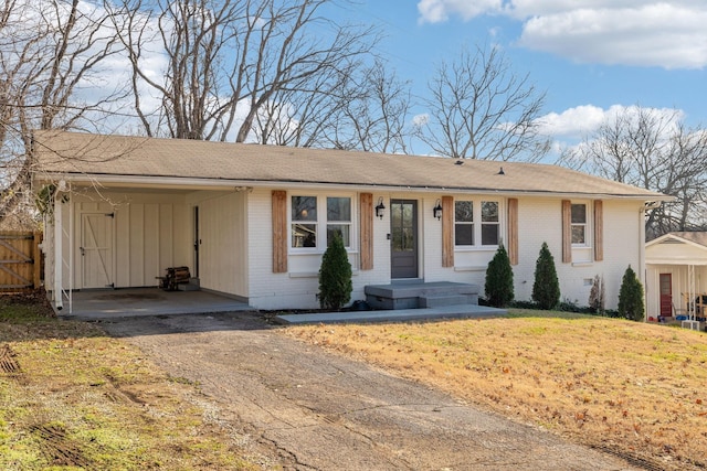 single story home with a front lawn and a carport