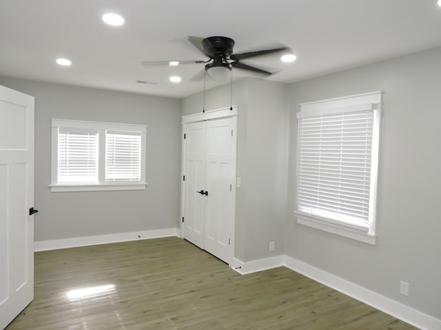 interior space with hardwood / wood-style floors, ceiling fan, and a closet