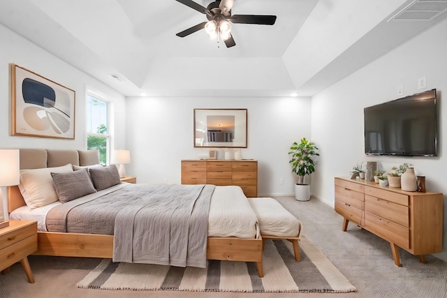 bedroom featuring a tray ceiling, ceiling fan, and light colored carpet