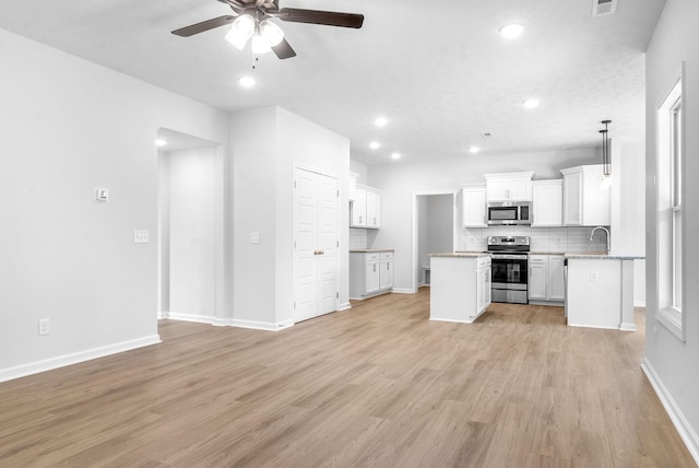 kitchen featuring backsplash, stainless steel appliances, ceiling fan, sink, and white cabinets