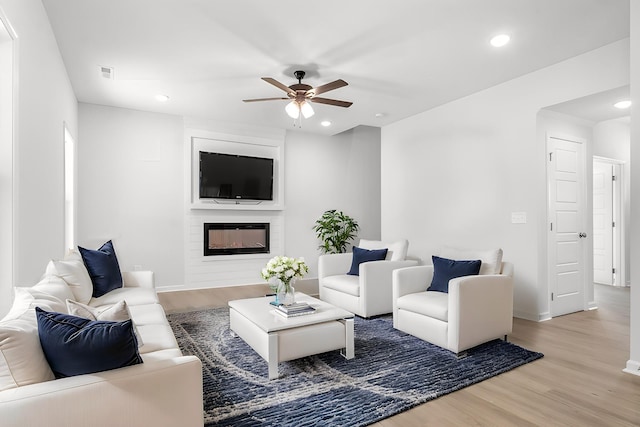 living room with light hardwood / wood-style floors and ceiling fan