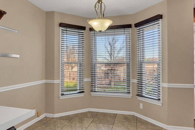 unfurnished dining area with light tile patterned flooring