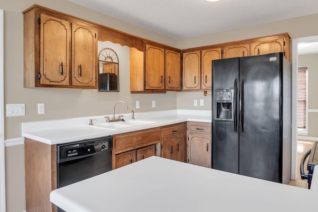 kitchen with sink, black appliances, and a textured ceiling