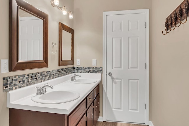 bathroom with backsplash, vanity, and wood-type flooring