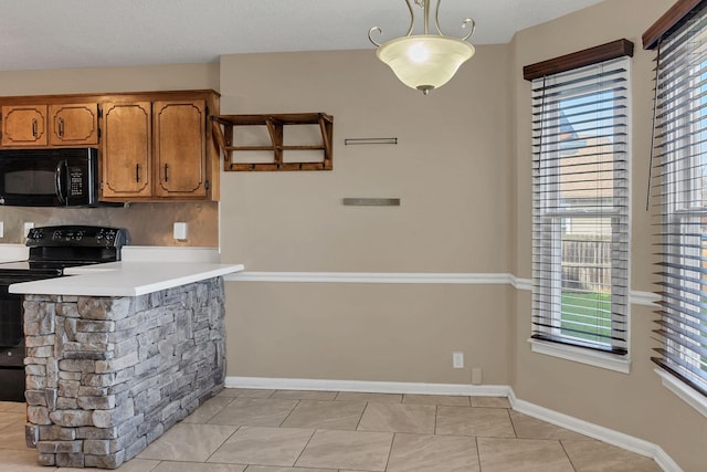 kitchen featuring black appliances, pendant lighting, and light tile patterned floors