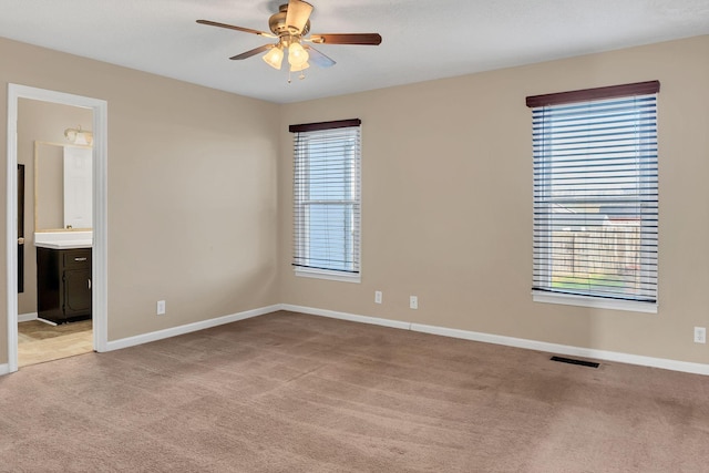 spare room featuring light colored carpet and ceiling fan