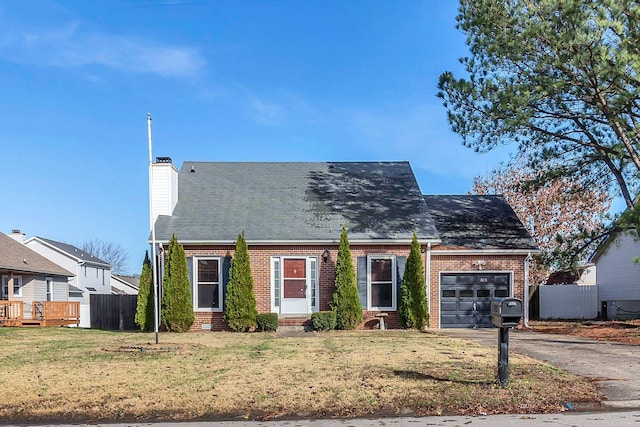 cape cod house featuring a garage and a front lawn