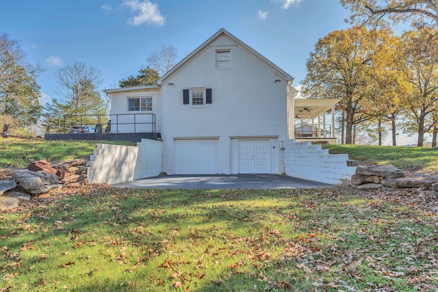 rear view of house with a lawn, a patio, and a garage