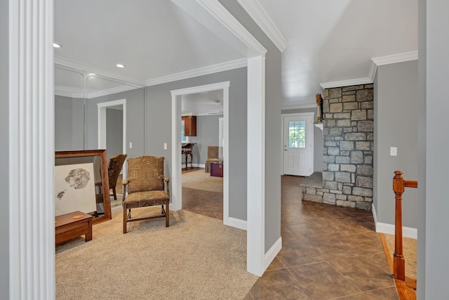 sitting room with ornamental molding and dark colored carpet