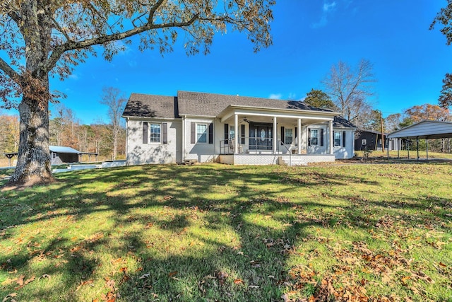 rear view of property with covered porch, a carport, and a lawn