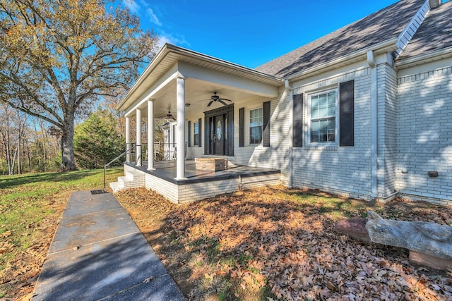 view of exterior entry featuring ceiling fan and covered porch