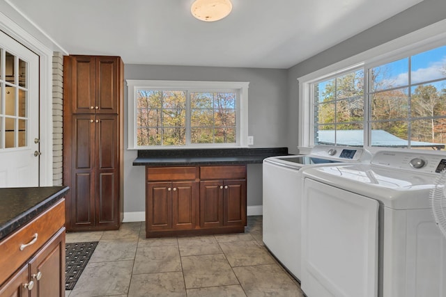 laundry area with cabinets, separate washer and dryer, and light tile patterned flooring