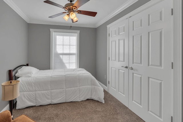 carpeted bedroom featuring a closet, ceiling fan, and ornamental molding