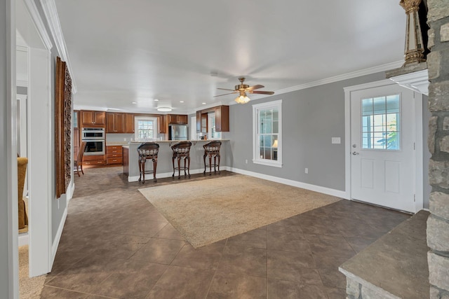 tiled living room with ceiling fan and ornamental molding