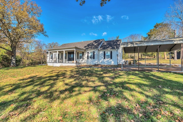 back of property featuring a lawn, covered porch, and a carport