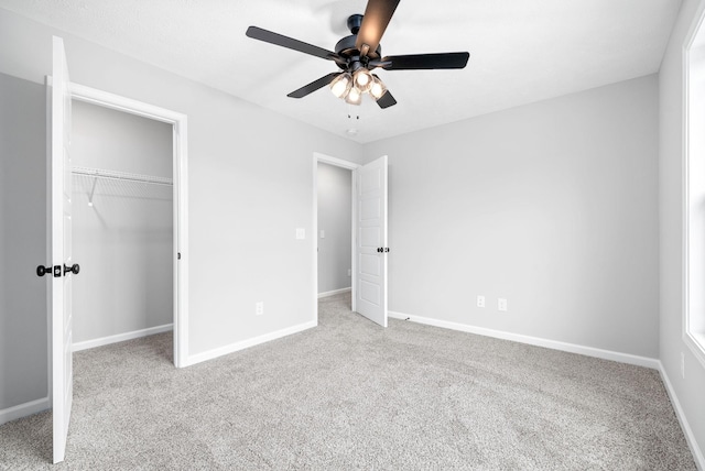 unfurnished bedroom featuring ceiling fan, light colored carpet, and a closet