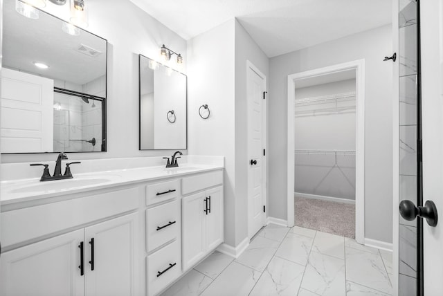 bathroom featuring a textured ceiling, vanity, and a shower with shower door