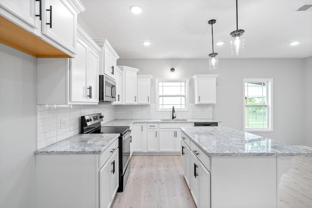 kitchen with pendant lighting, stainless steel appliances, white cabinetry, and sink