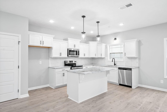 kitchen with white cabinets, stainless steel appliances, and a kitchen island