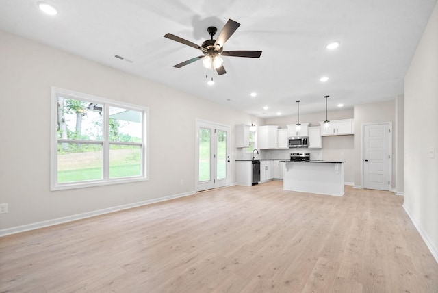 unfurnished living room with light wood-type flooring and ceiling fan