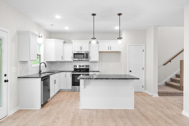 kitchen with white cabinets, sink, a kitchen island, and stainless steel appliances