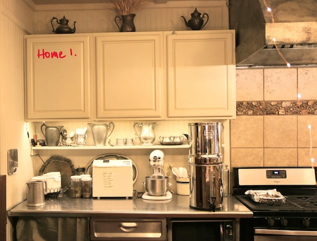 bar with gas stove, white cabinets, and ventilation hood