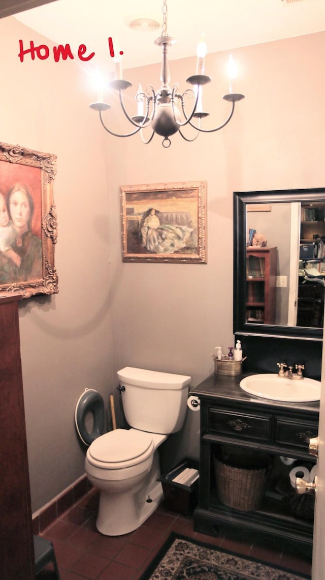 bathroom with tile patterned flooring, vanity, a chandelier, and toilet