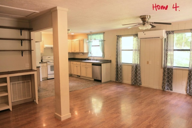 kitchen with stainless steel dishwasher, white electric range oven, a wall unit AC, ceiling fan, and sink