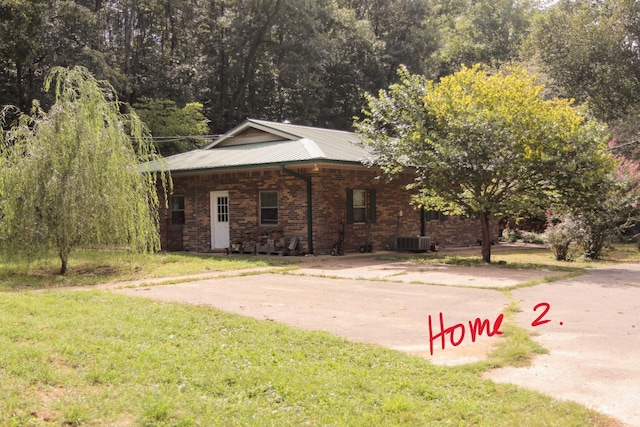 view of side of property featuring central AC and a yard