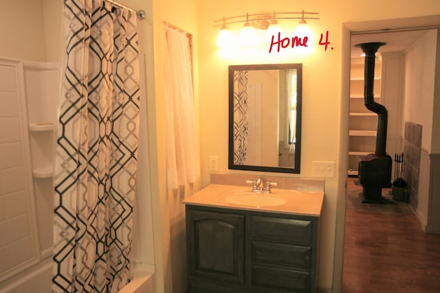 bathroom with hardwood / wood-style flooring, vanity, and shower / tub combo