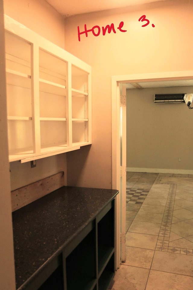 kitchen with light tile patterned floors and a wall unit AC