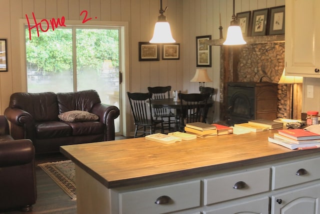 living room with a wood stove and wooden walls