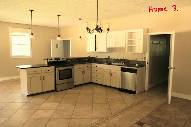 kitchen with kitchen peninsula, appliances with stainless steel finishes, decorative light fixtures, and tile patterned floors