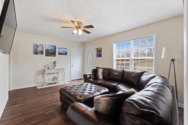 living room featuring ceiling fan, dark hardwood / wood-style floors, and a textured ceiling