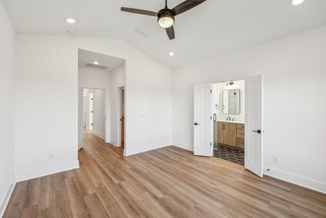 unfurnished bedroom with vaulted ceiling, ceiling fan, sink, light hardwood / wood-style flooring, and connected bathroom