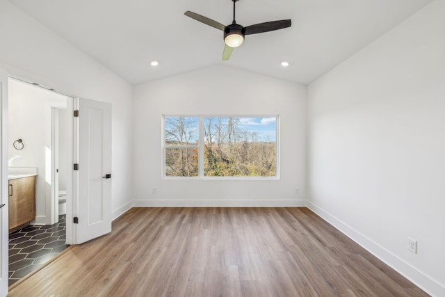 unfurnished bedroom featuring ensuite bathroom, dark hardwood / wood-style flooring, ceiling fan, and lofted ceiling