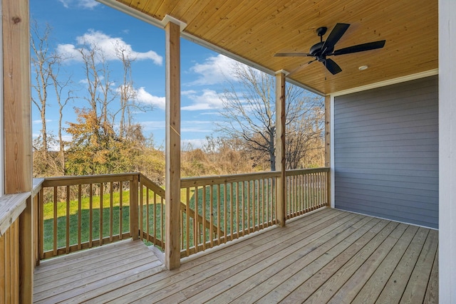 wooden terrace featuring ceiling fan and a yard