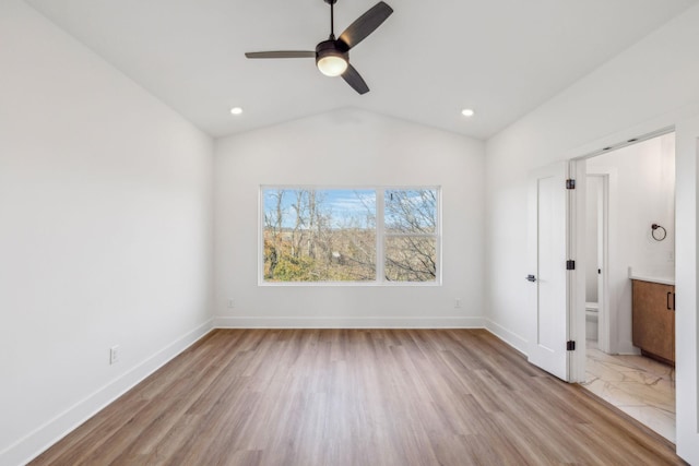 unfurnished bedroom featuring light wood-type flooring, ensuite bath, ceiling fan, and lofted ceiling