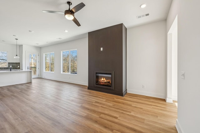 unfurnished living room with light hardwood / wood-style floors and ceiling fan