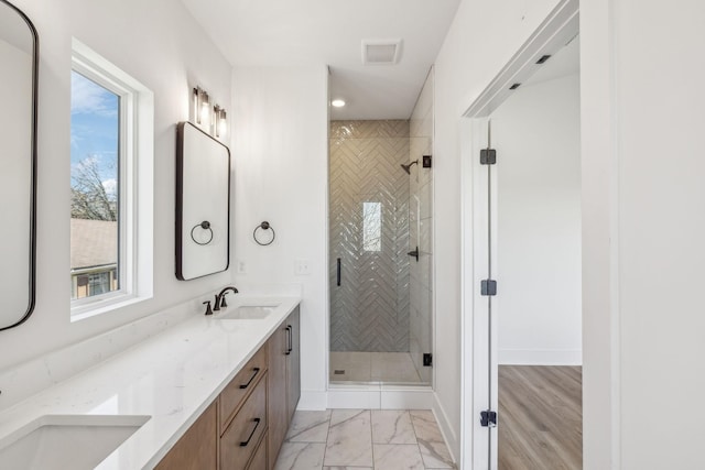 bathroom with a wealth of natural light, vanity, and a shower with shower door