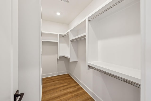 spacious closet with hardwood / wood-style flooring