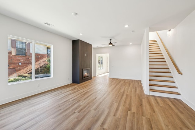 unfurnished living room with a fireplace, light hardwood / wood-style floors, and ceiling fan