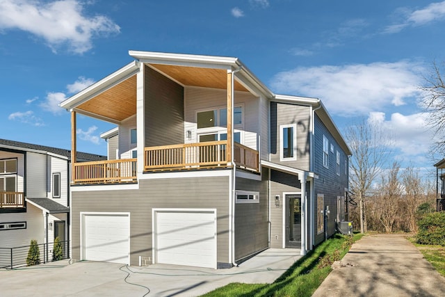 view of front of home with central AC unit, a garage, and a balcony